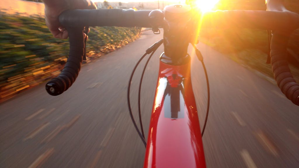 Experience the thrill of cycling at sunset, capturing speed and motion on a scenic road.