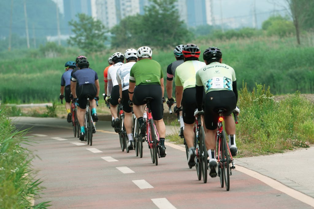 Group of cyclists riding in a line on an urban bike path in Paju, South Korea, showcasing teamwork and fitness.